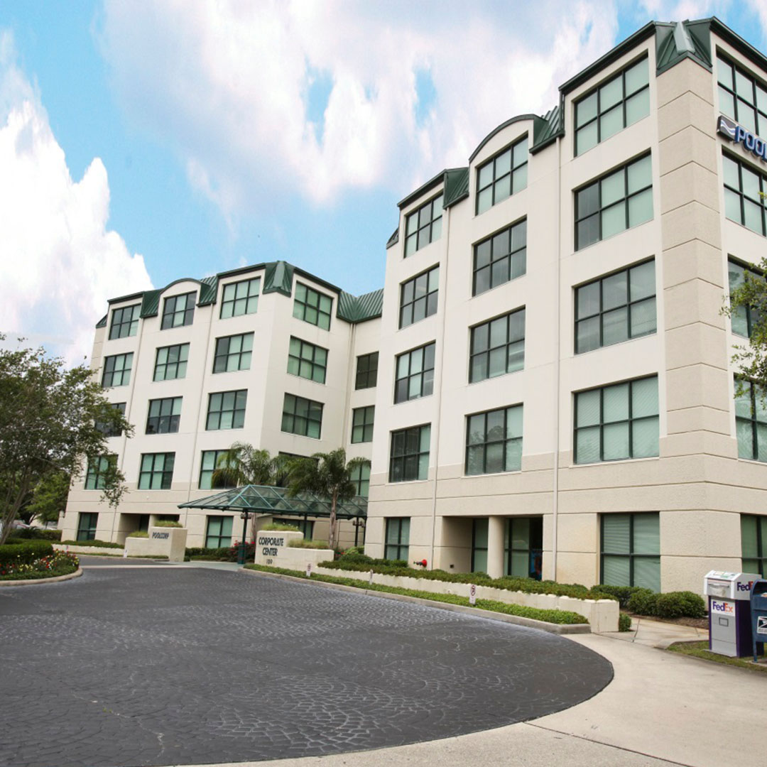 Modern office building with green accents and a covered entrance.